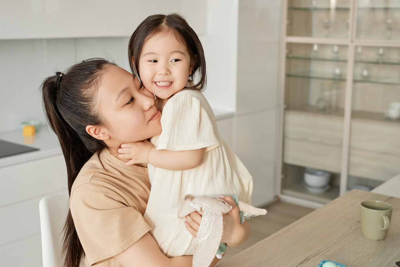 Mom embracing her little daughter