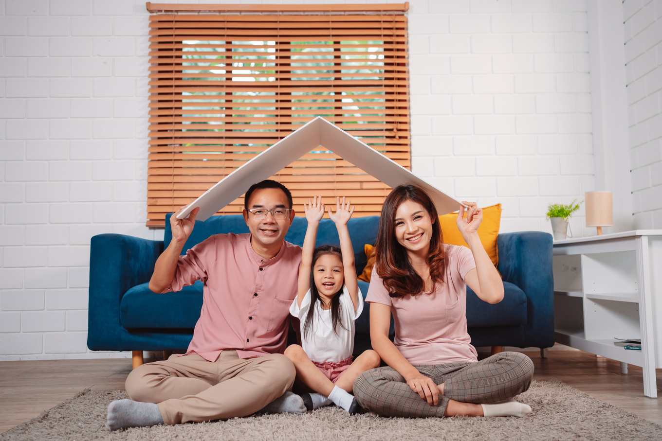 Happy Family home insurance roof protecting house and daughter. holding cardboard covering for family protection.